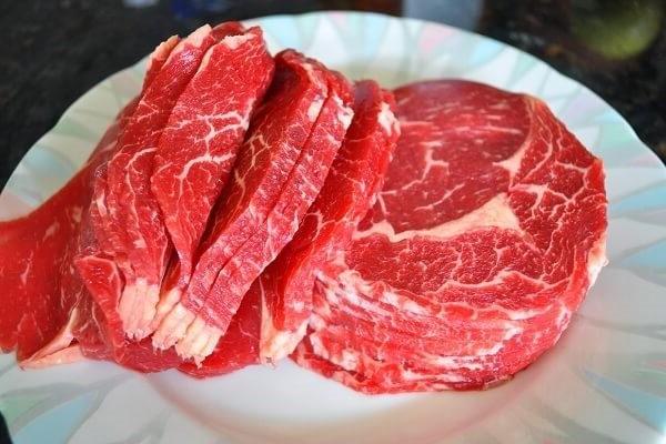 Thịt bò thái mỏng và cho vào tô, ướp thịt để trong 10 - 15 phút